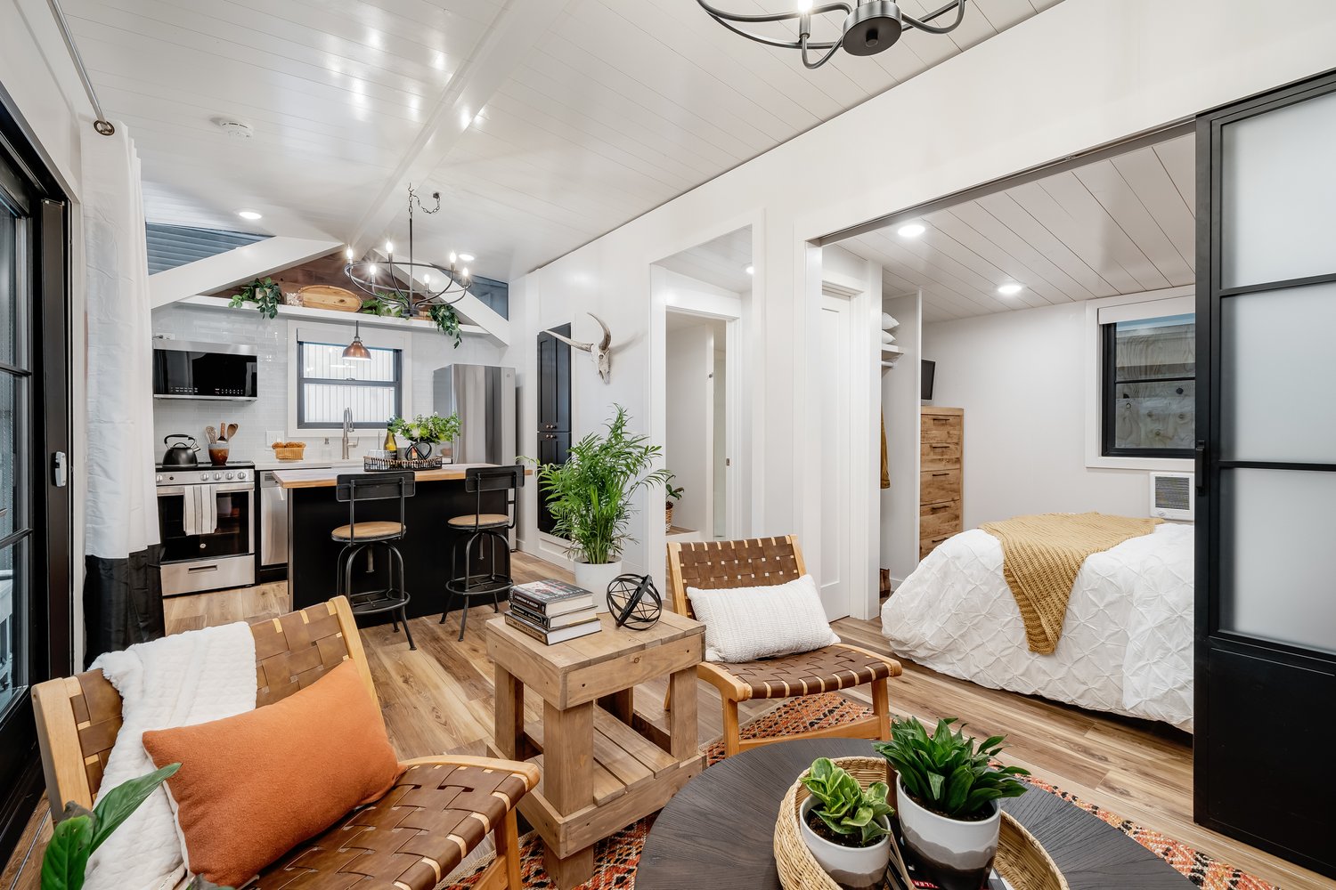 Spacious 400-sqft single-level tiny home with a slide-out living room, queen bedroom, full kitchen with island, huge closet, washer/dryer hookups & more.